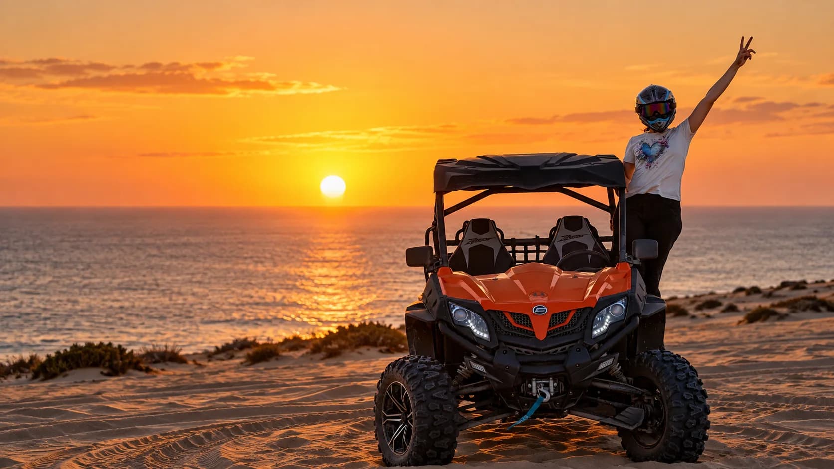 Rider standing on an off-road buggy above the Atlantic at sunset on the Timlaline dunes.
