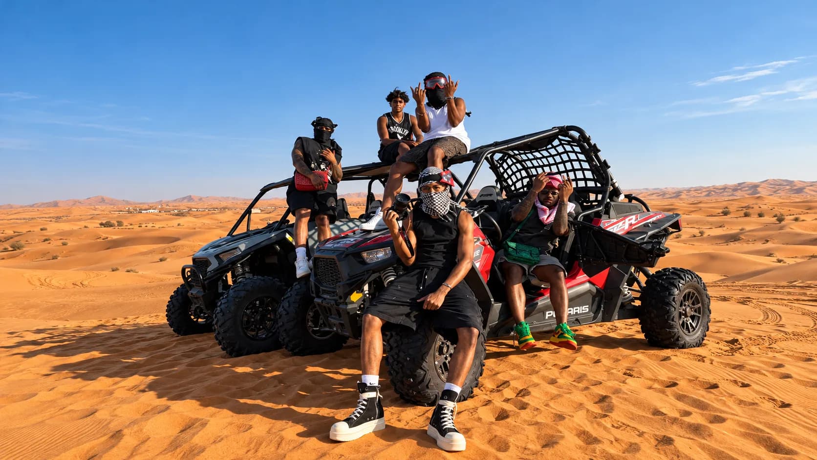 Group of riders posing on two side-by-side buggies in the desert dunes near Agadir.