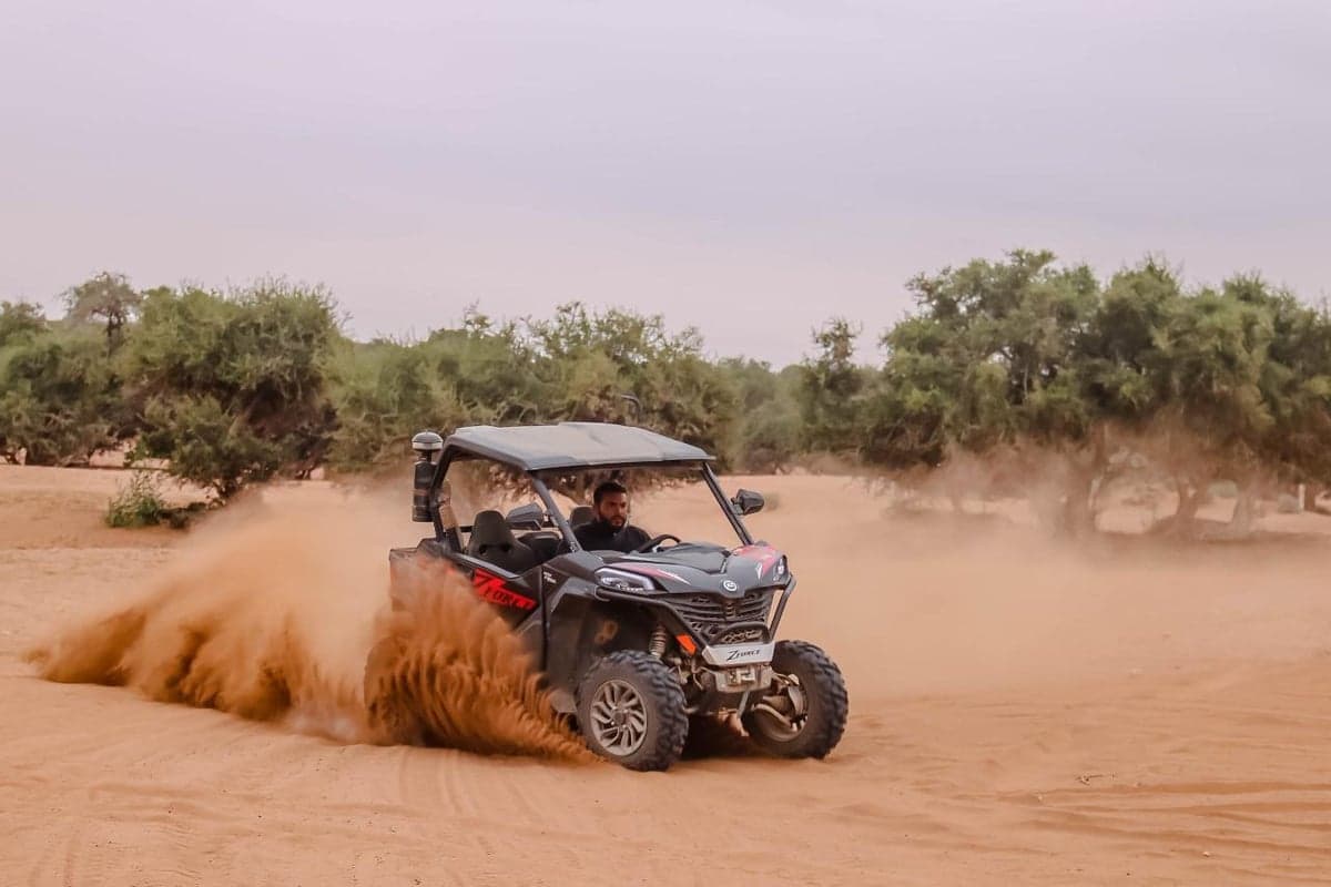Side-by-side desert buggy driving through Agadir dunes on a guided off-road tour.