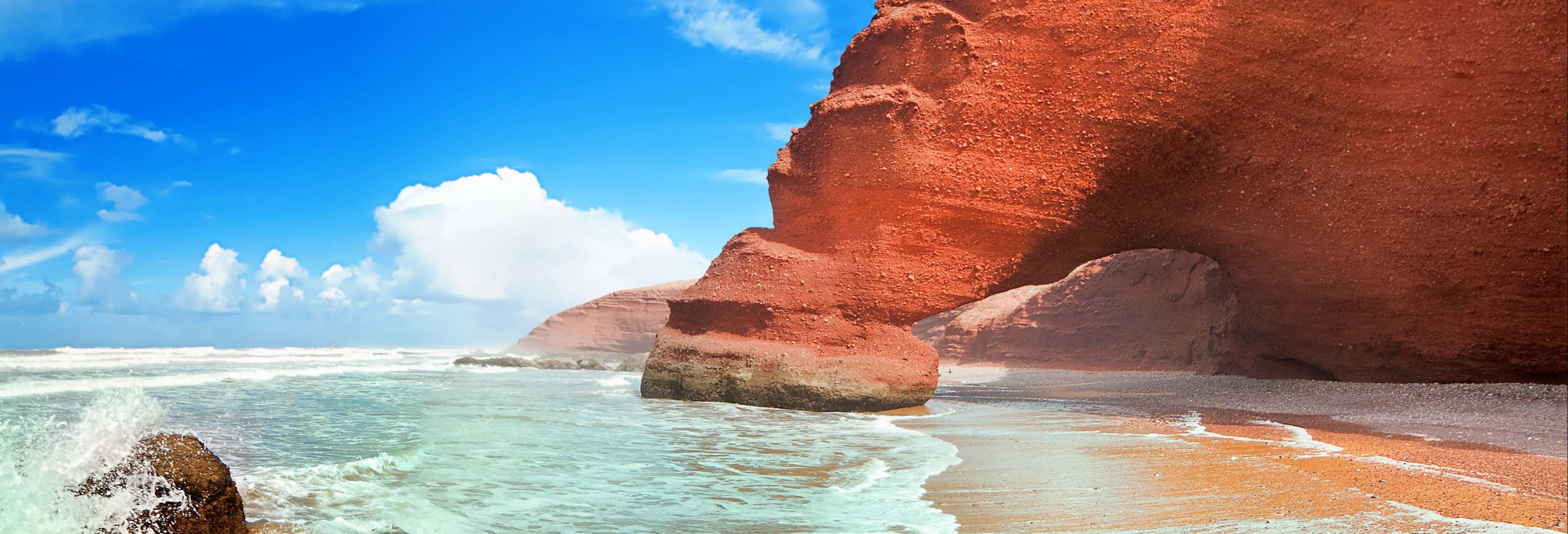 The iconic red stone natural arches of Legzira beach rising from the Atlantic on a day trip from Agadir.