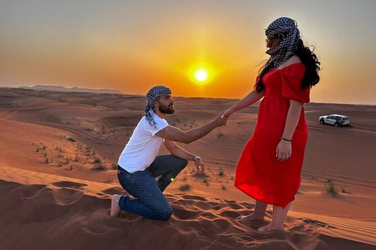 Traveler sandboarding down golden Timlalin dunes on a tour from Agadir